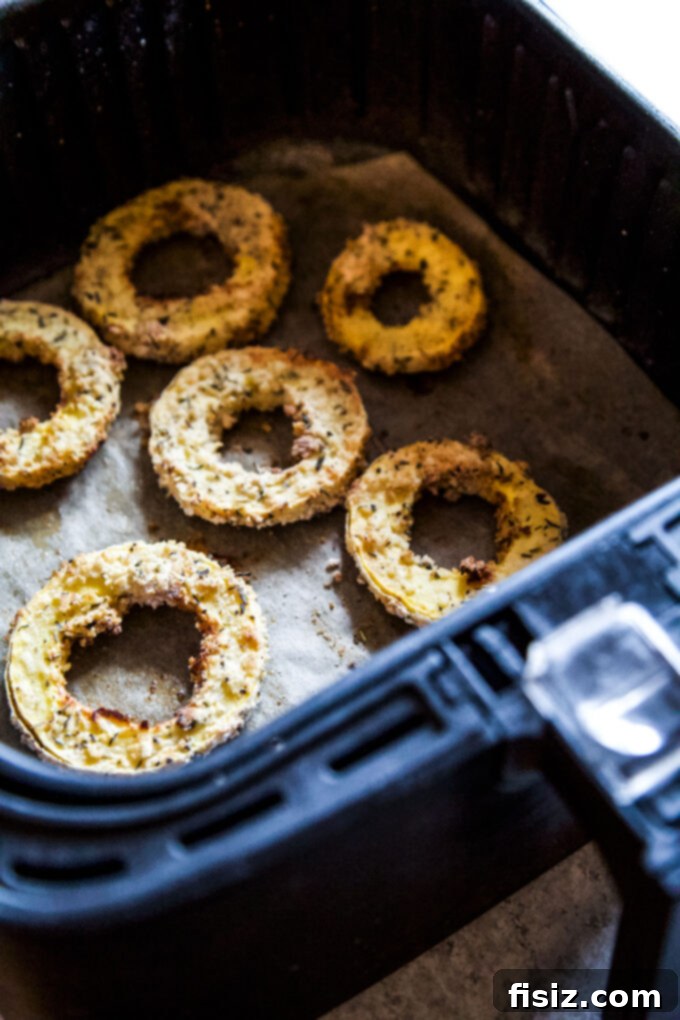 Crispy Air Fryer Squash Rings 7 Delicata squash rings cooking in an air fryer basket
