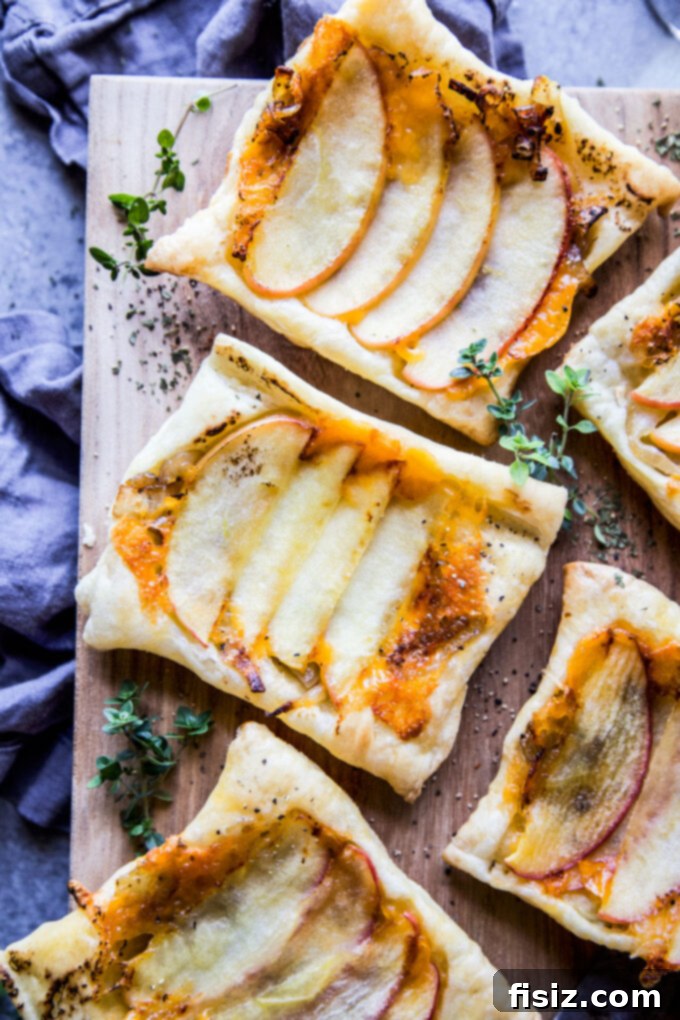 Artfully arranged Apple & Cheddar Upside Down Tart with Caramelized Rum Onions on a serving board