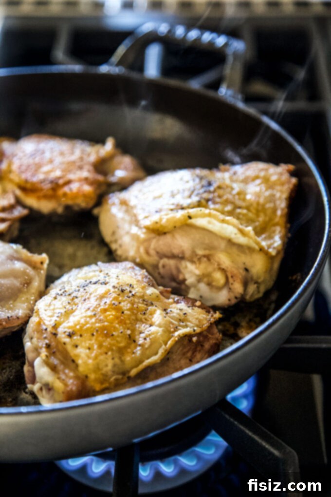 Fragrant Thai Chicken Dumpling Delight 8 Chicken thighs searing in a Dutch oven, a key step for flavorful Thai Chicken and Dumplings.