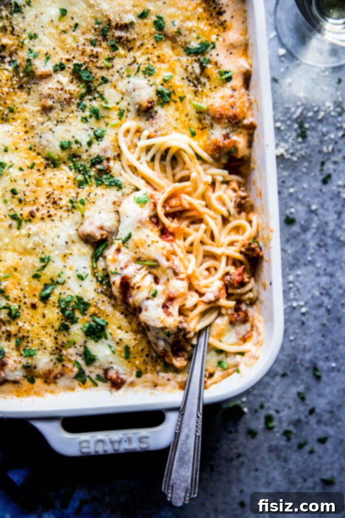 Creamy Baked Alfredo Spaghetti 3 A close-up view of the baked Spaghetti Alfredo Casserole, showcasing the perfectly melted and golden-brown cheese topping.