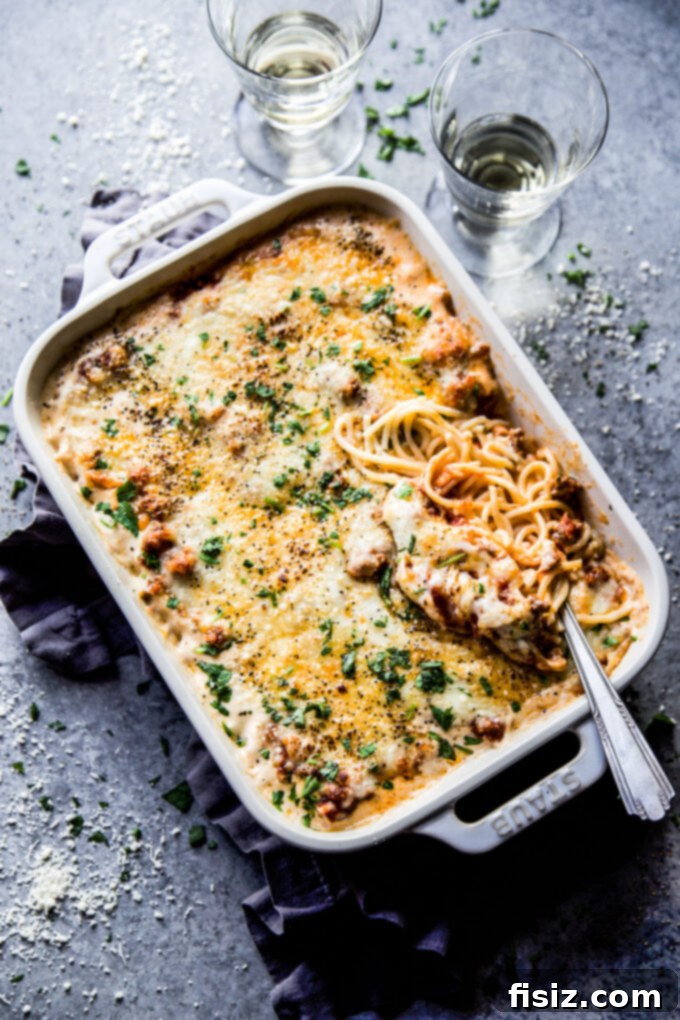 Creamy Baked Alfredo Spaghetti 7 A freshly baked Spaghetti Alfredo Casserole, showcasing a golden-brown, bubbly cheese topping and vibrant colors, ready to be served.