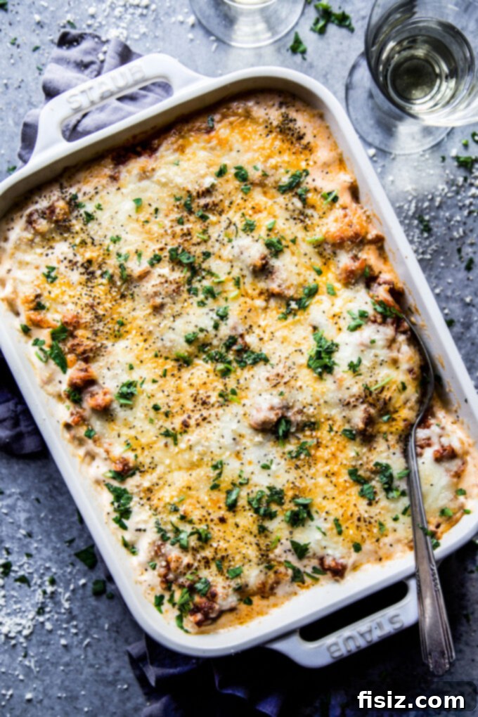 Creamy Baked Alfredo Spaghetti 8 A generous serving of Spaghetti Alfredo Casserole in a bowl, garnished with fresh parsley, ready to be enjoyed.