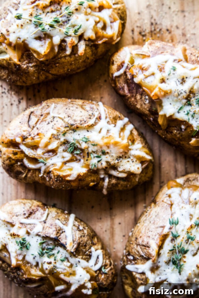 Ultimate French Onion Baked Potatoes 3 Close-up of a perfectly baked potato overflowing with French onion filling and melted cheese.