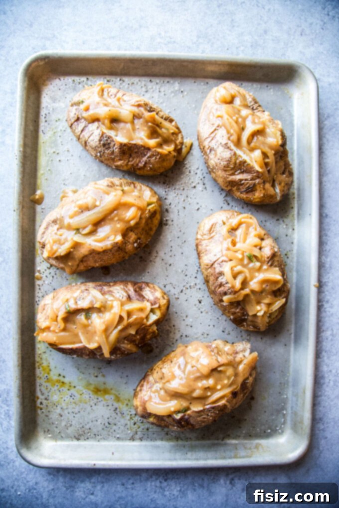 Ultimate French Onion Baked Potatoes 6 Multiple French onion baked potatoes on a baking sheet, fresh out of the oven.