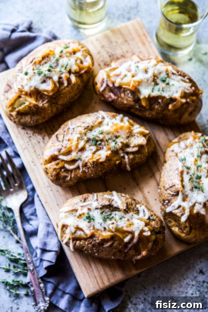 Ultimate French Onion Baked Potatoes 7 A close-up shot of a French onion baked potato, with golden melted cheese and fresh thyme.