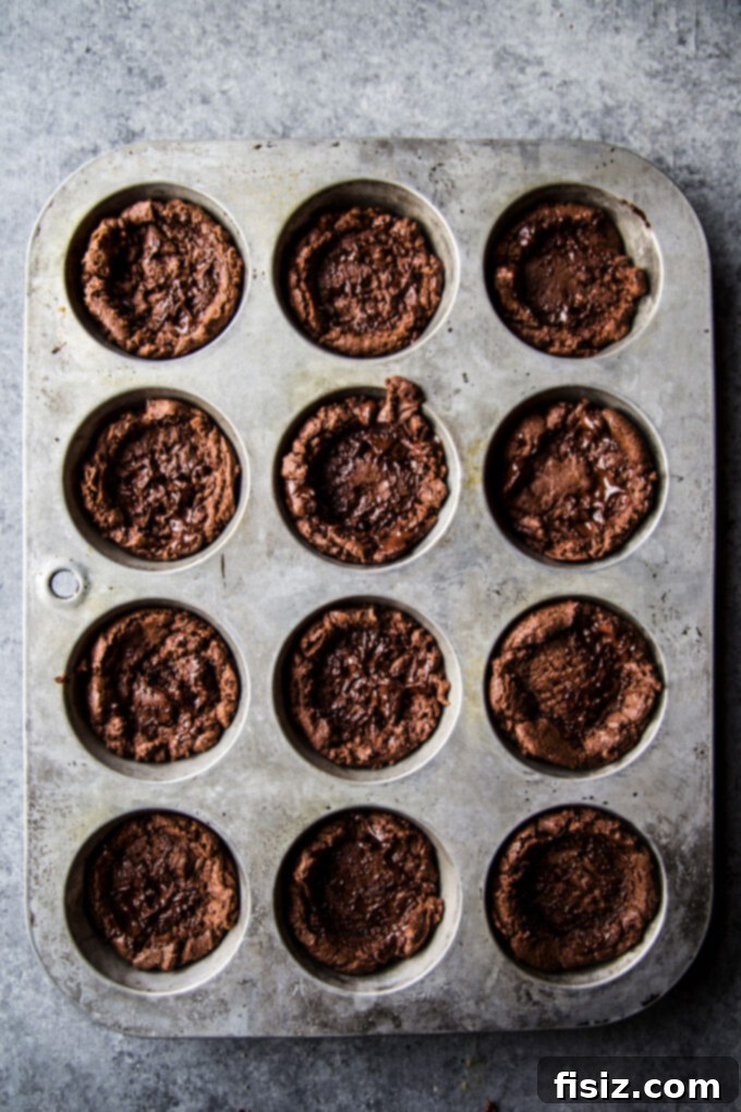 Frosty Peppermint Cream Chocolate Cookie Cups 5 Baked chocolate cookie cups in a muffin pan, showing their perfectly formed indentations
