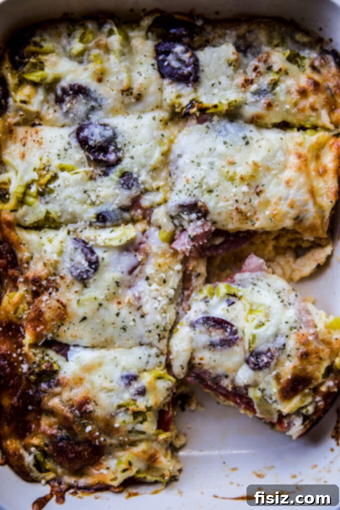 Savory Italian Brunch Bake 7 A close-up of a delicious slice of Easy Antipasto Breakfast Casserole with melted cheese and visible layers of meat and vegetables