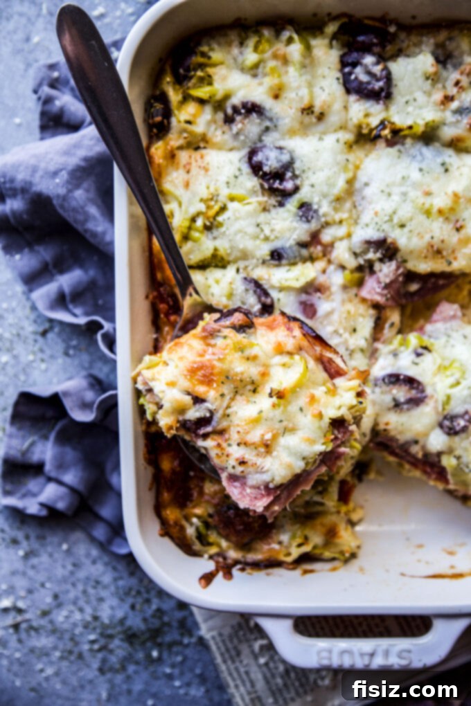 Savory Italian Brunch Bake 8 A beautifully presented slice of Antipasto Breakfast Casserole on a white plate, garnished with fresh herbs