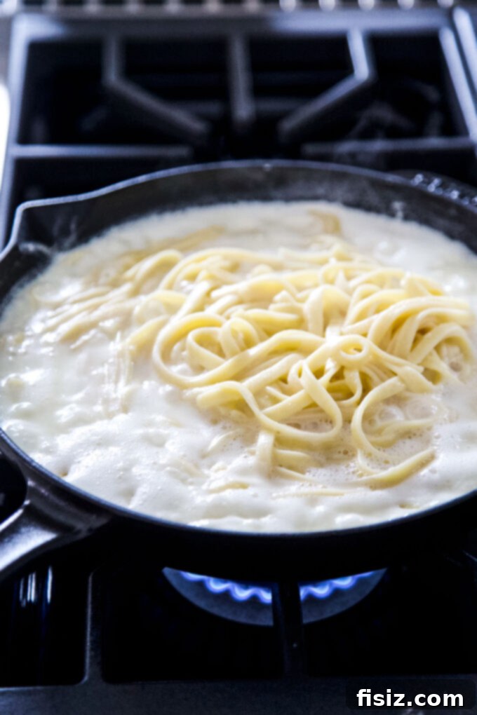 Effortless Creamy Cottage Cheese Alfredo 7 Cottage cheese Fettuccine Alfredo sauce mixed with noodles in a skillet