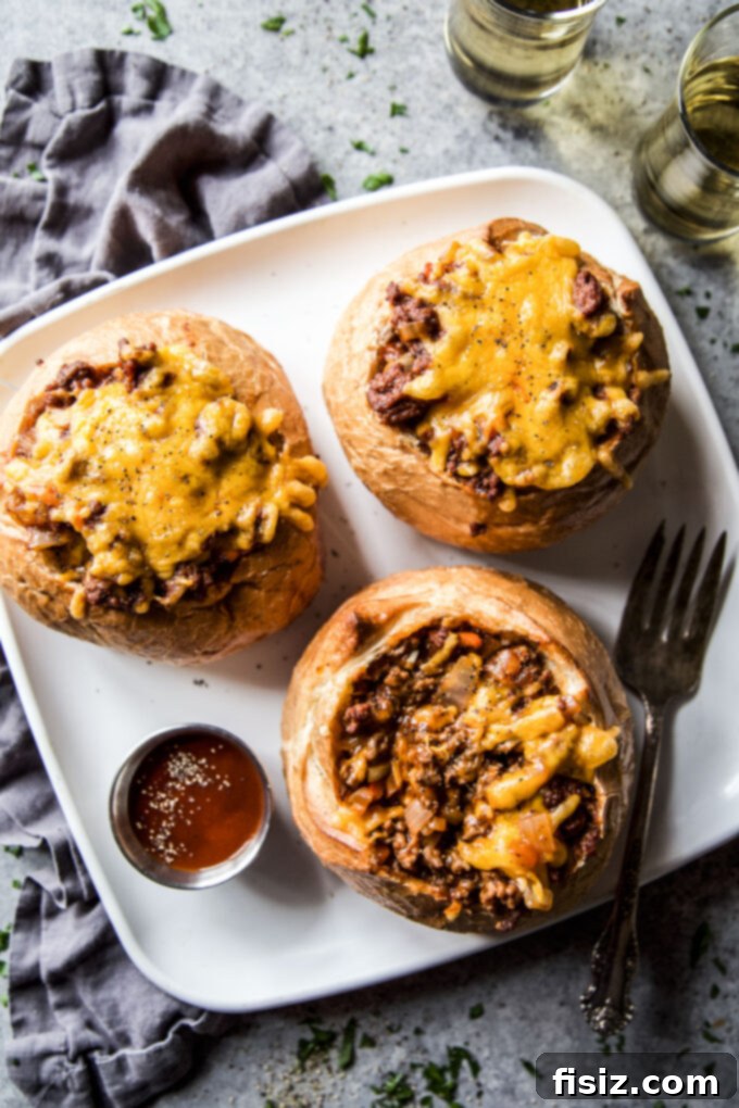 Loaded BBQ Sloppy Joe Bread Bowls 7 Two perfectly cooked BBQ Sloppy Joe Bread Bowls on a rustic wooden serving board