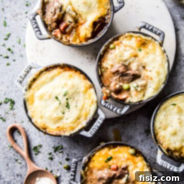 Individual American Lamb Shoulder Shepherd's Pie 19 Close-up of a Mini American Lamb Shoulder Shepherd's Pie, golden-brown mashed potato topping with herbs.
