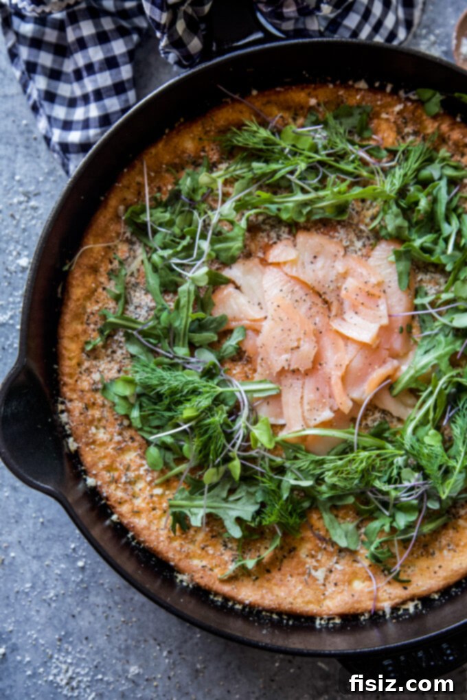 Herbed Protein Skillet Cakes 3 Two high protein herbed skillet pancakes topped with fresh herbs and smoked salmon on a wooden board. www.thecuriousplate.com