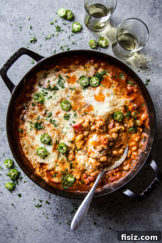 One-Pan Chorizo and White Bean Enchilada Bake 2 Crispy chorizo and white bean enchilada skillet, garnished with fresh herbs, ready to eat.
