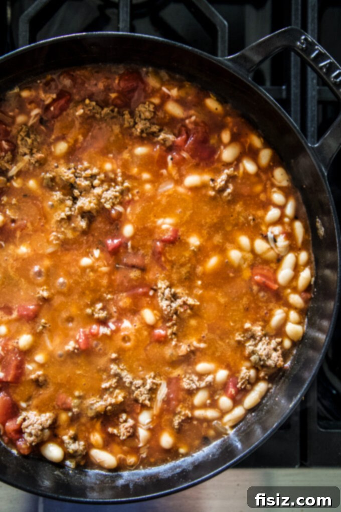 One-Pan Chorizo and White Bean Enchilada Bake 4 Close-up of the rich red enchilada sauce simmering in a cast iron skillet.