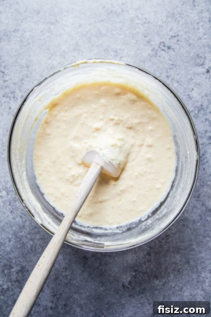 Velvety Citrus Ricotta Cake with a Bright Orange Drizzle 5 Cake batter being poured into a cake pan, ready for baking