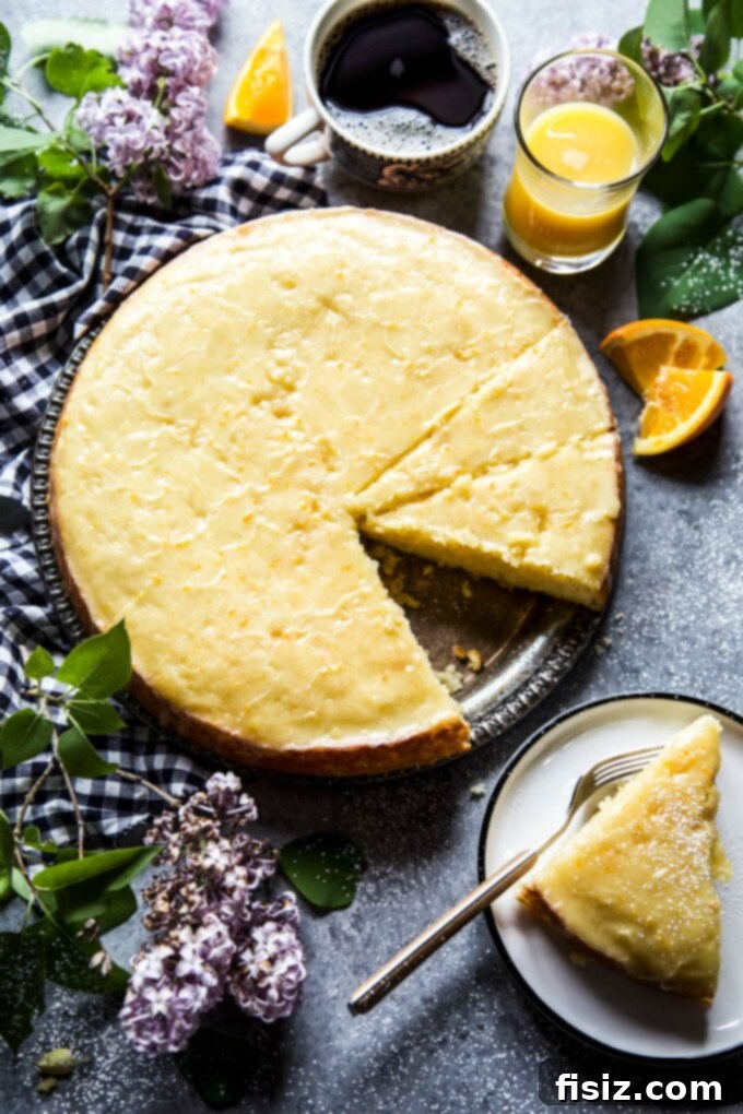 Velvety Citrus Ricotta Cake with a Bright Orange Drizzle 8 A full Citrus Ricotta Cake with orange glaze on a white cake stand