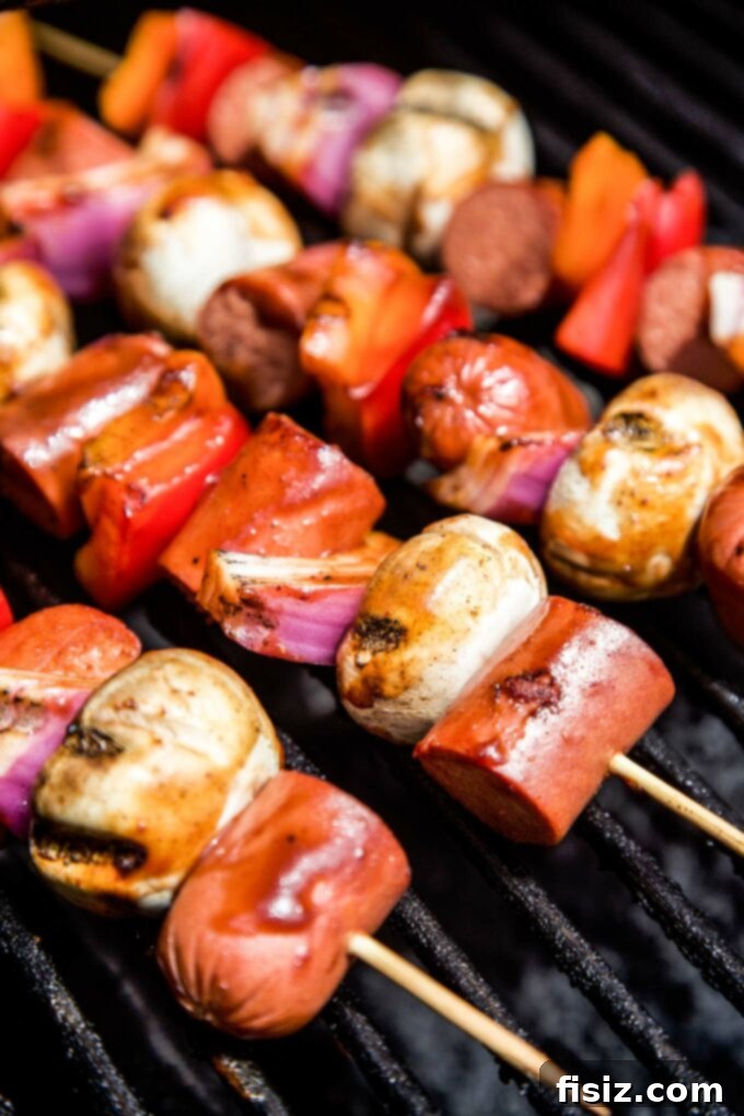 Epic Hot Dog Skewers 7 Loaded Hot Dog Skewers grilling over an open flame, with smoke rising and perfect char marks.