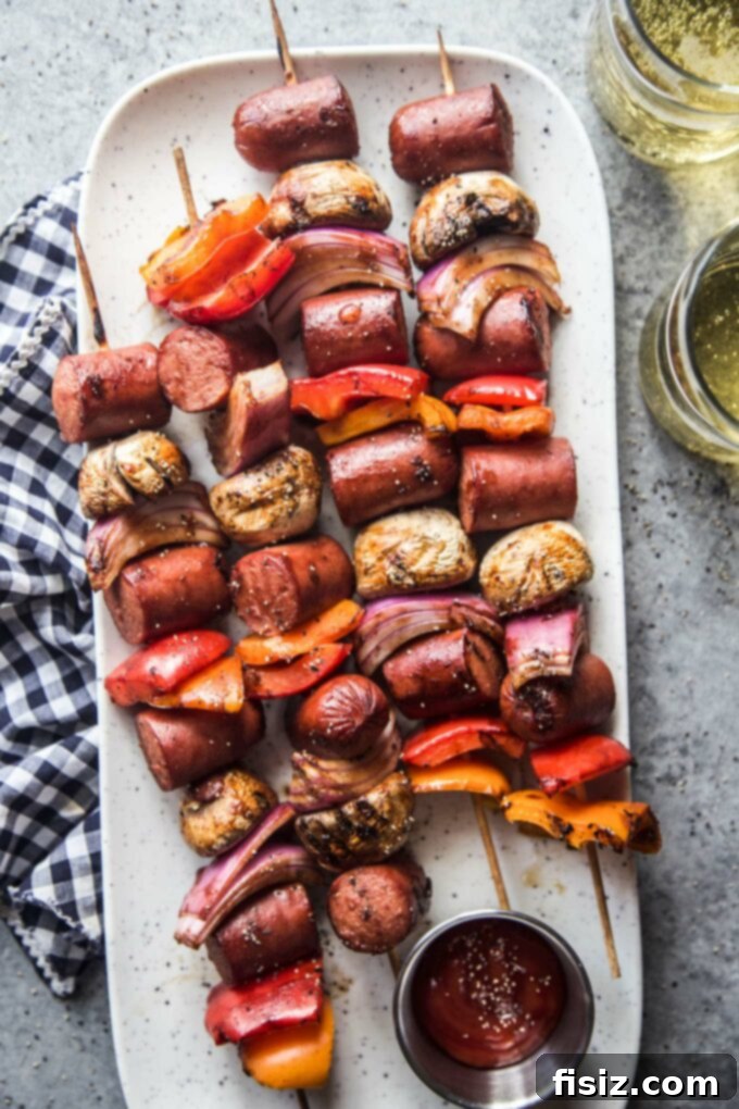Epic Hot Dog Skewers 8 Several perfectly grilled Loaded Hot Dog Skewers resting on a plate, garnished with fresh herbs and ready to serve.