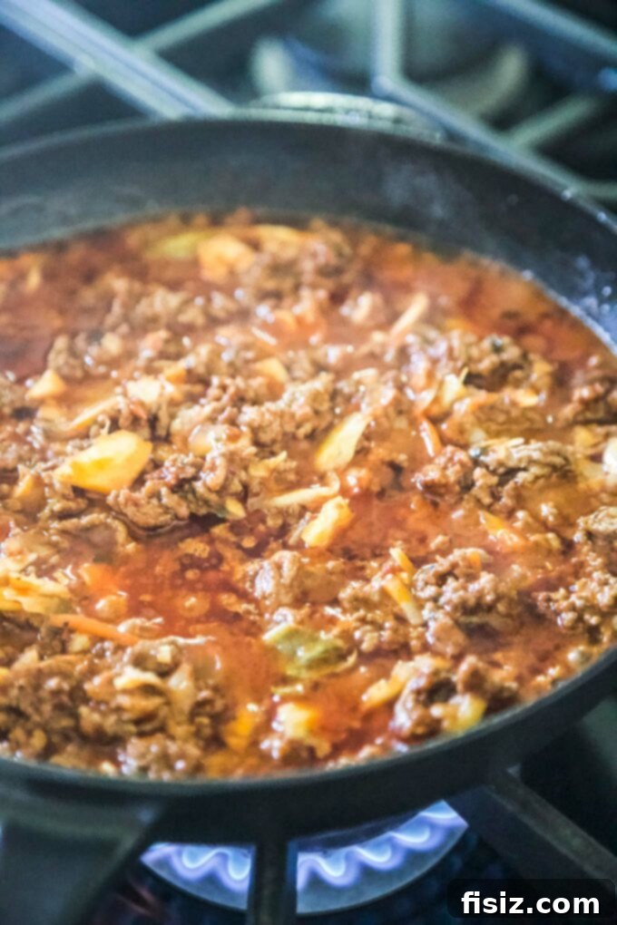 Korean BBQ Nachos Supreme 6 Close-up of seasoned ground beef mixed with kimchi in a skillet, simmering to perfection for the nachos.