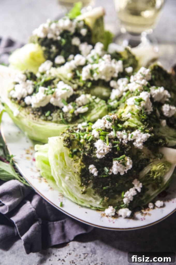 Zesty Tabouli Wedge 3 Close-up of the Easy Tabouli-Style Wedge Salad, showing the rich green dressing, crumbled goat cheese, and fresh chives on a crisp lettuce wedge.