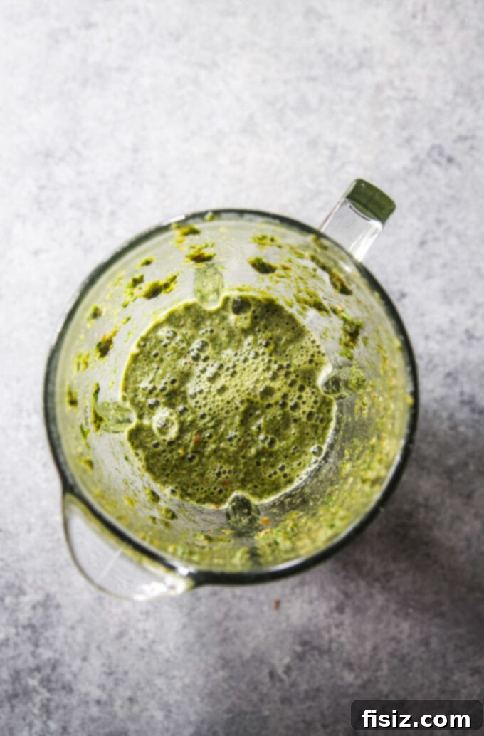 Zesty Tabouli Wedge 5 Blended tabouli-style dressing ingredients, showing the smooth, vibrant green liquid in a food processor, ready for straining.