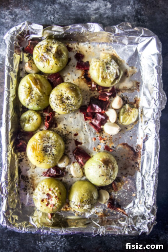Tangy Heat Pumpkin Tomatillo Salsa 5 Roasted tomatillos and garlic on a baking sheet, golden and slightly charred.