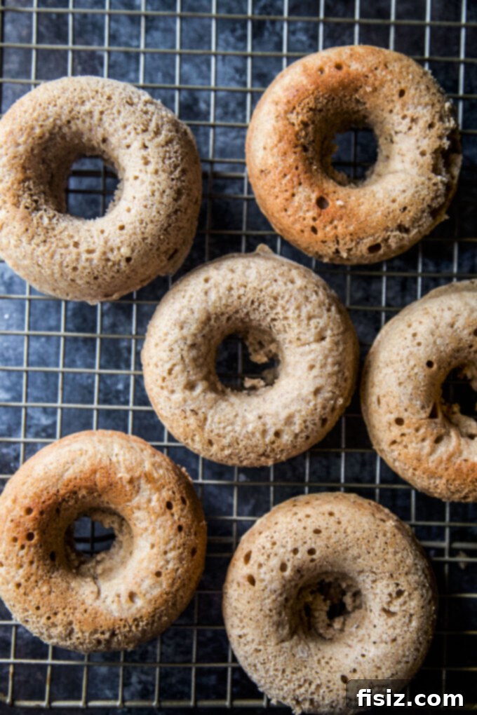 Heavenly Baked Coconut Cardamom Pecan Doughnuts 7 A baked doughnut being coated with coconut and pecan sugar mixture