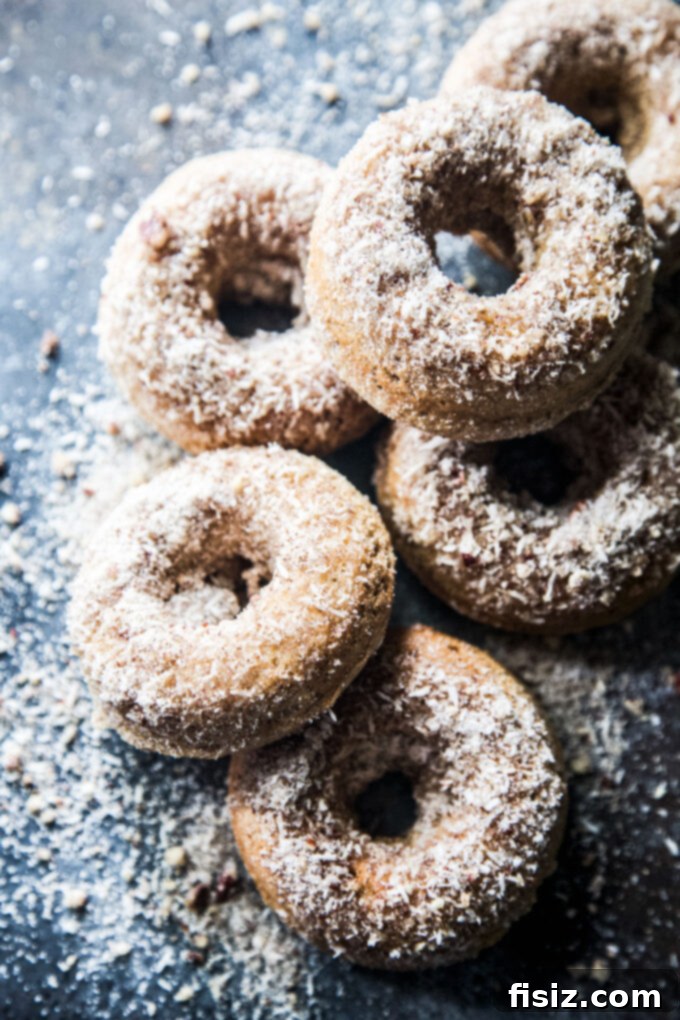 Heavenly Baked Coconut Cardamom Pecan Doughnuts 8 An assortment of Coconut Cardamom Pecan Baked Doughnuts, some coated, some plain