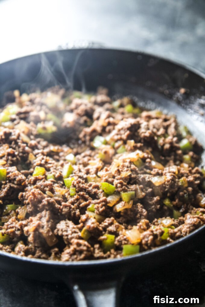 Loaded Chili Cheese Pizza 5 Ground beef chili mix cooking in a skillet with vegetables and spices