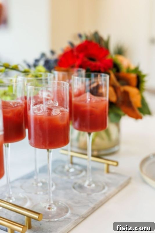 Five Keys to Stress-Free Holiday Hosting 5 Hand holding a glass of Pomegranate Spritzer with walnuts on a charcuterie board