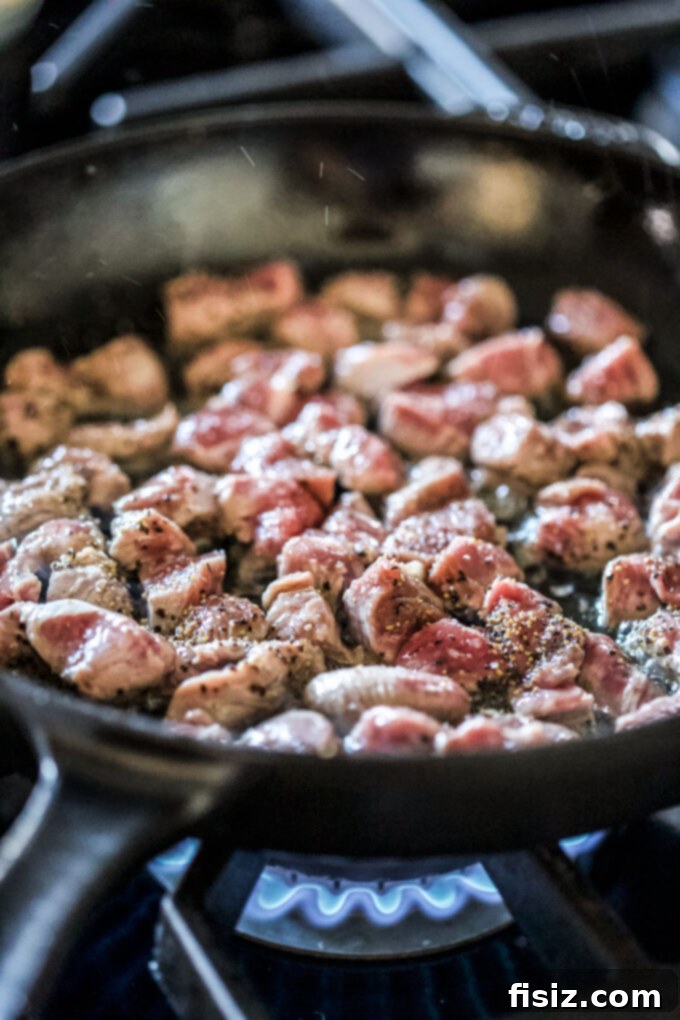 Individual Lamb Wellingtons 6 Lamb leg roast cubes cooking in a skillet, essential for Mini Lamb Wellington Bites