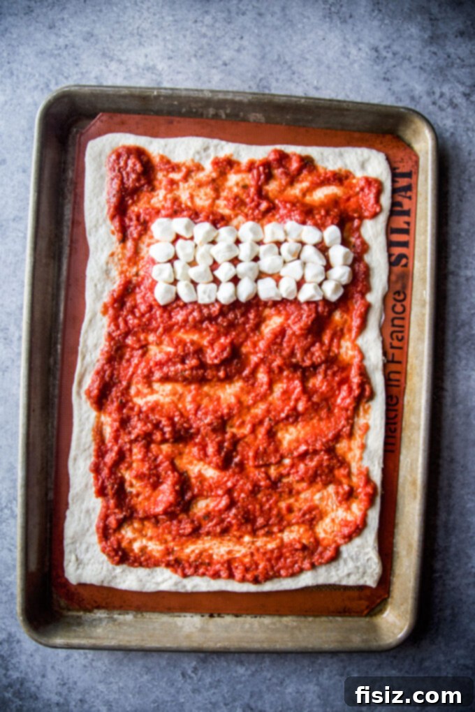 Close up of pizza with pearl mozzarella balls neatly arranged on top