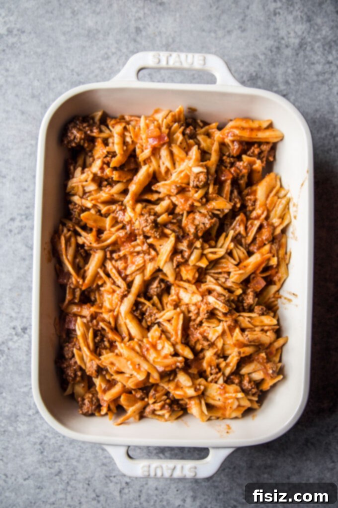 ziti lamb mixture in a dish before baking