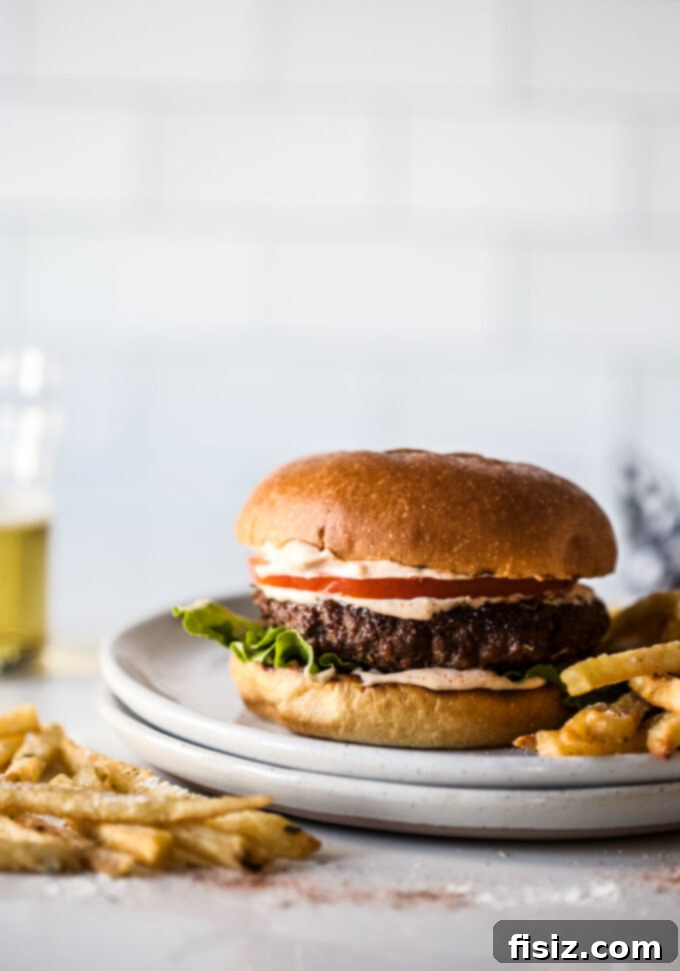 Creole Skillet Burger with Zesty Ranch Fries 2 Skillet Creole Burger with Crispy Ranch French Fries on a wooden board with fresh ingredients