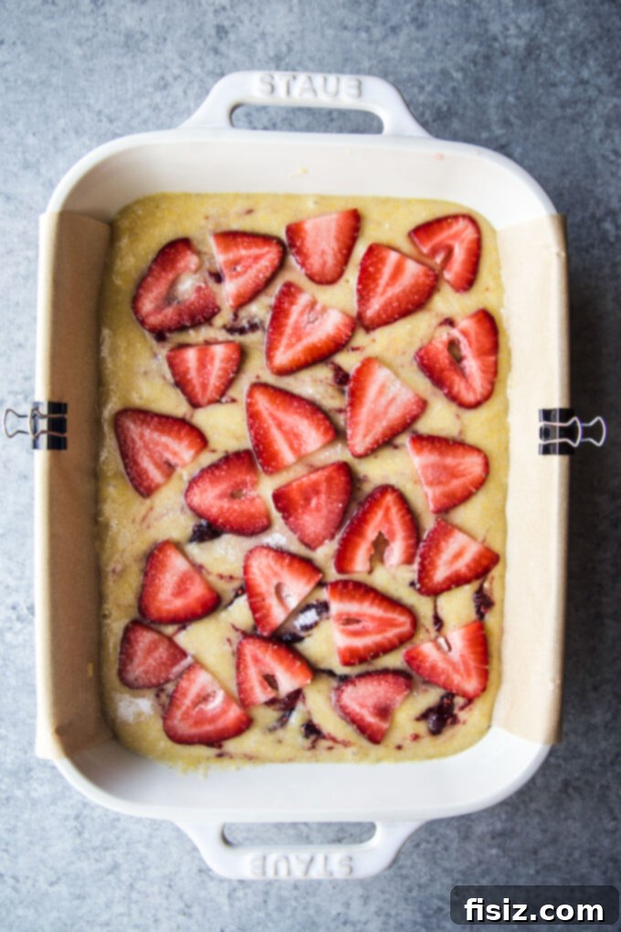 Strawberry Cardamom Protein Cake 8 batter topped with fresh strawberries, ready for baking