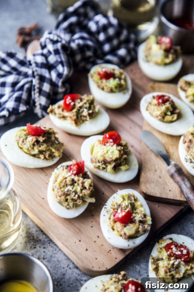 Deli-Style Chopped Cheese Deviled Eggs 8 Plate of gourmet Chopped Cheese Deviled Eggs, beautifully garnished with tomato and sesame seeds