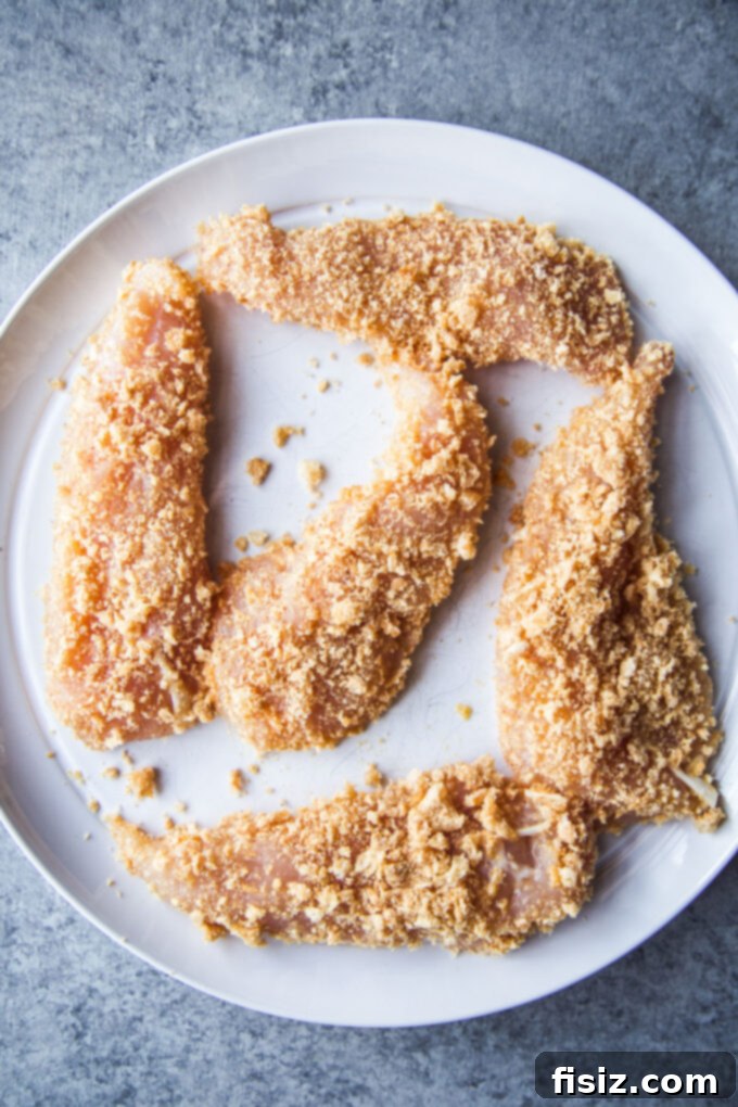 Crispy chicken tenders coated with chicharrones on a plate