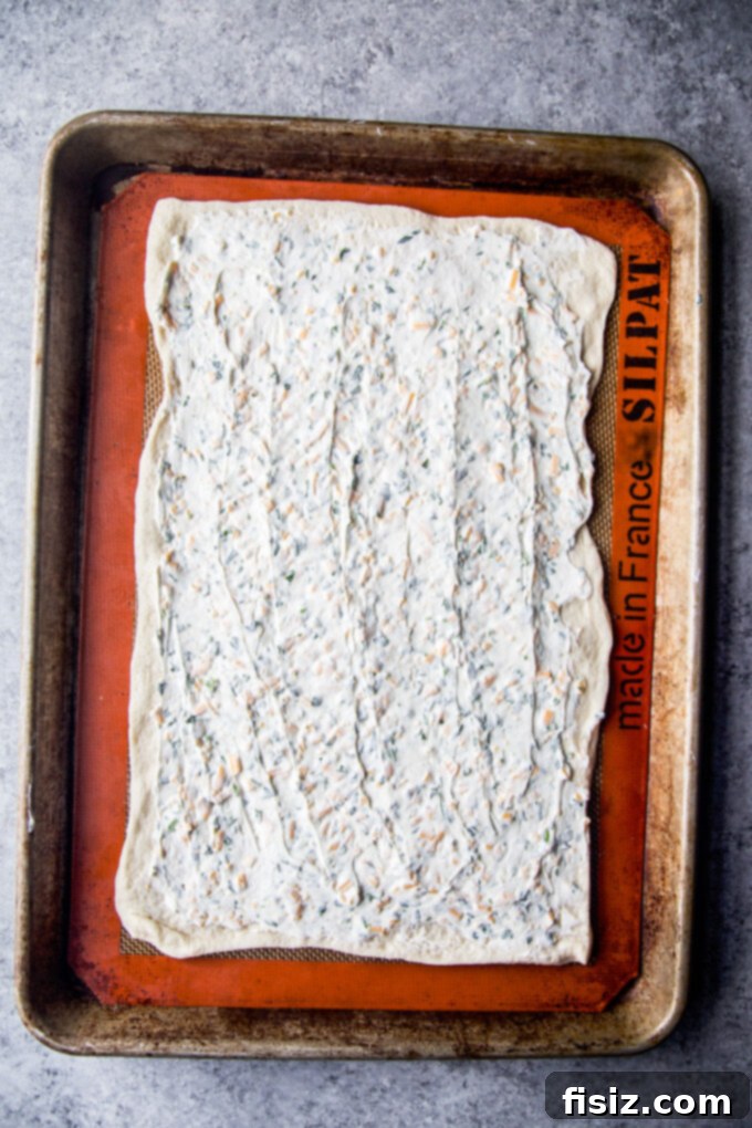 Bagel and Lox Pull-Apart Loaf with Cream Cheese 5 Cream cheese mixture spread evenly onto a rolled-out pizza dough rectangle