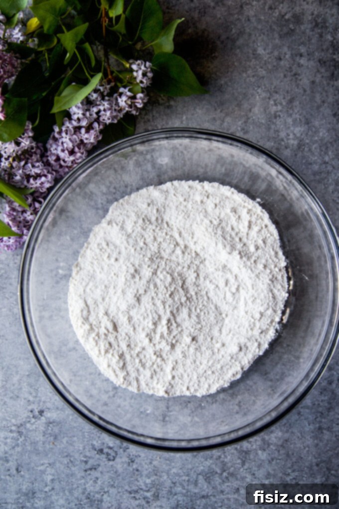 A bowl of dry ingredients for Coconut Lime Ricotta Muffins, ready to be mixed.