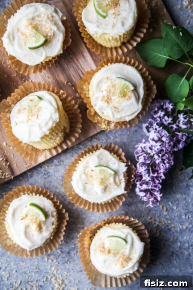 Variety of Coconut Lime Ricotta Muffins, including blueberry, mango, and chocolate chip variations, displayed on a wooden board.