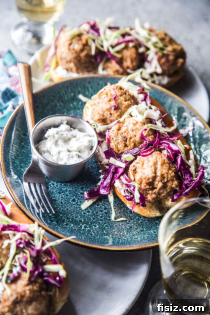 Spiced Shawarma Chicken Meatball Subs with Tangy Za'atar Slaw 3 Two halves of a Chicken Shawarma Meatball Sub with Za’atar Slaw, showcasing the juicy meatballs and colorful slaw inside a bun.