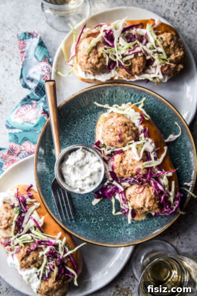 Spiced Shawarma Chicken Meatball Subs with Tangy Za'atar Slaw 8 A fully assembled Chicken Shawarma Meatball Sub, with a focus on the fresh and flavorful ingredients.