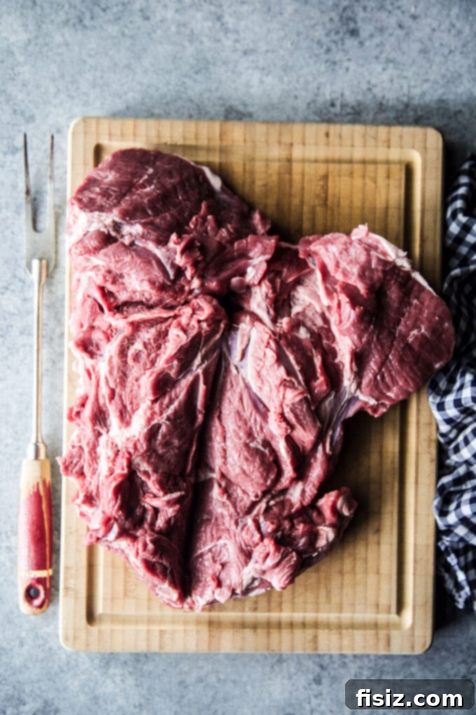 Tikka Masala Spiced American Butterflied Lamb 5 Raw butterflied leg of lamb on a cutting board, pre-marination, showing its flat cut.