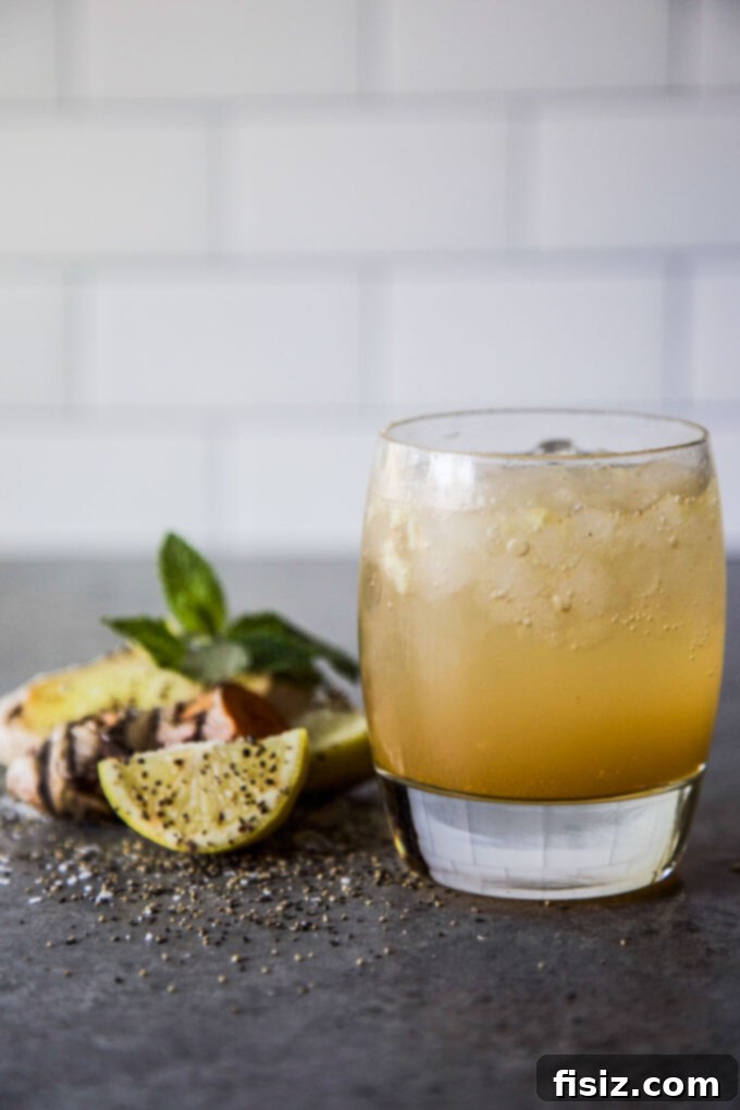Beat the Bloat: 3 DIY Tonics for Thanksgiving Digestion 9 A glass of the refreshing Lemon Cider Tonic, complete with ice and a lemon wedge, offering a zesty approach to digestive relief.