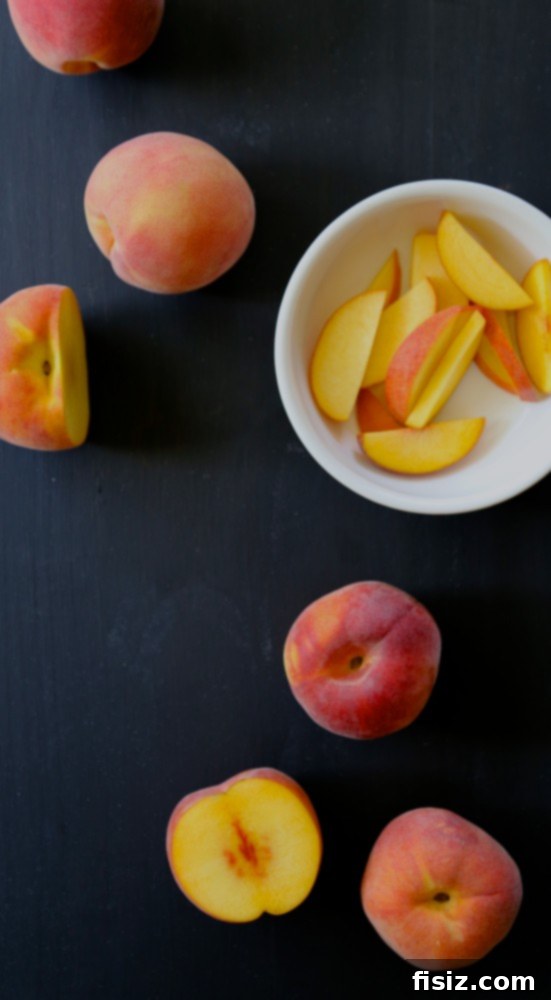 Foodie Fridays Peach Rosemary Bourbon Sparkler 4 A bounty of fresh, ripe peaches displayed in a rustic wooden bowl, showcasing their vibrant colors and velvety textures, ready for a delicious recipe.