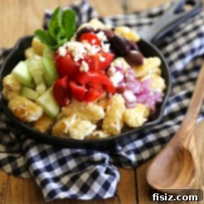 Close-up of a delightful Greek Feta Gnocchi Skillet with creamy whipped feta, pan-fried gnocchi, and a colorful assortment of Mediterranean vegetables, garnished with fresh herbs.