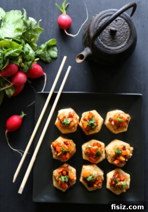 A close-up shot of an assembled spicy Asian chicken puff pastry bite, showcasing the flaky pastry and vibrant filling.