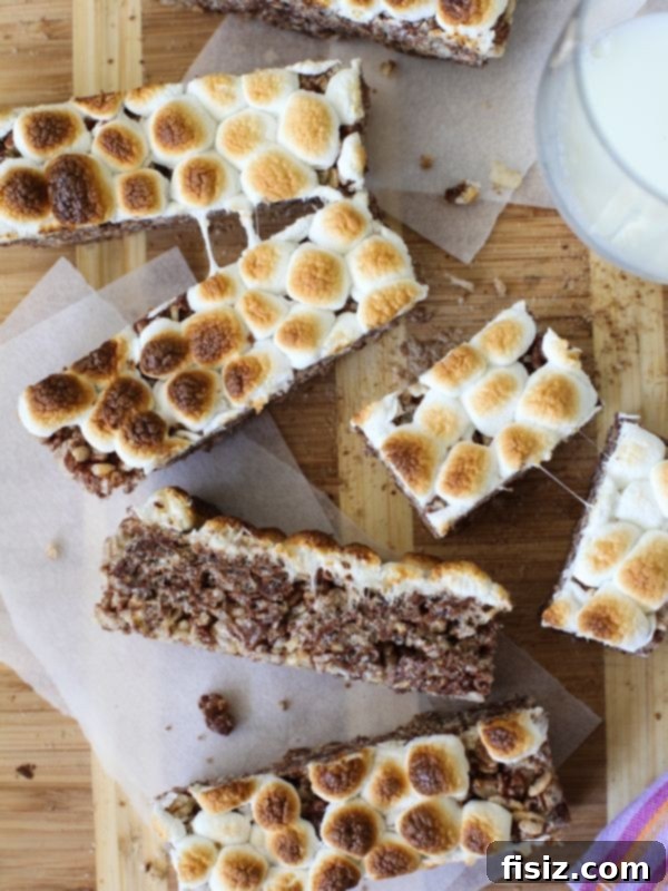 Chewy S'mores Krispies Bars, combining crispy rice cereal with gooey marshmallow, chocolate, and graham cracker pieces.