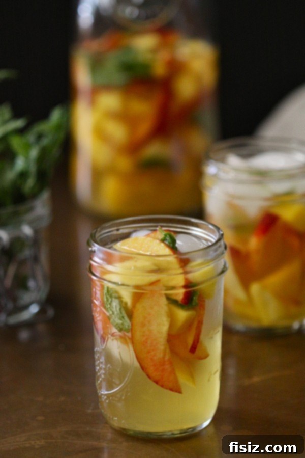 Tropical Mango, Mint, and Peach Sangria in a glass with fruit slices