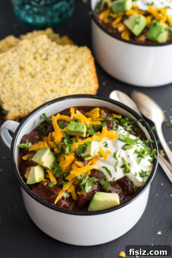 10 Ultimate Tailgate Chili Recipes 12 A bowl of Jalapeno Lime Black Bean Texas Chili, garnished with fresh herbs and lime.